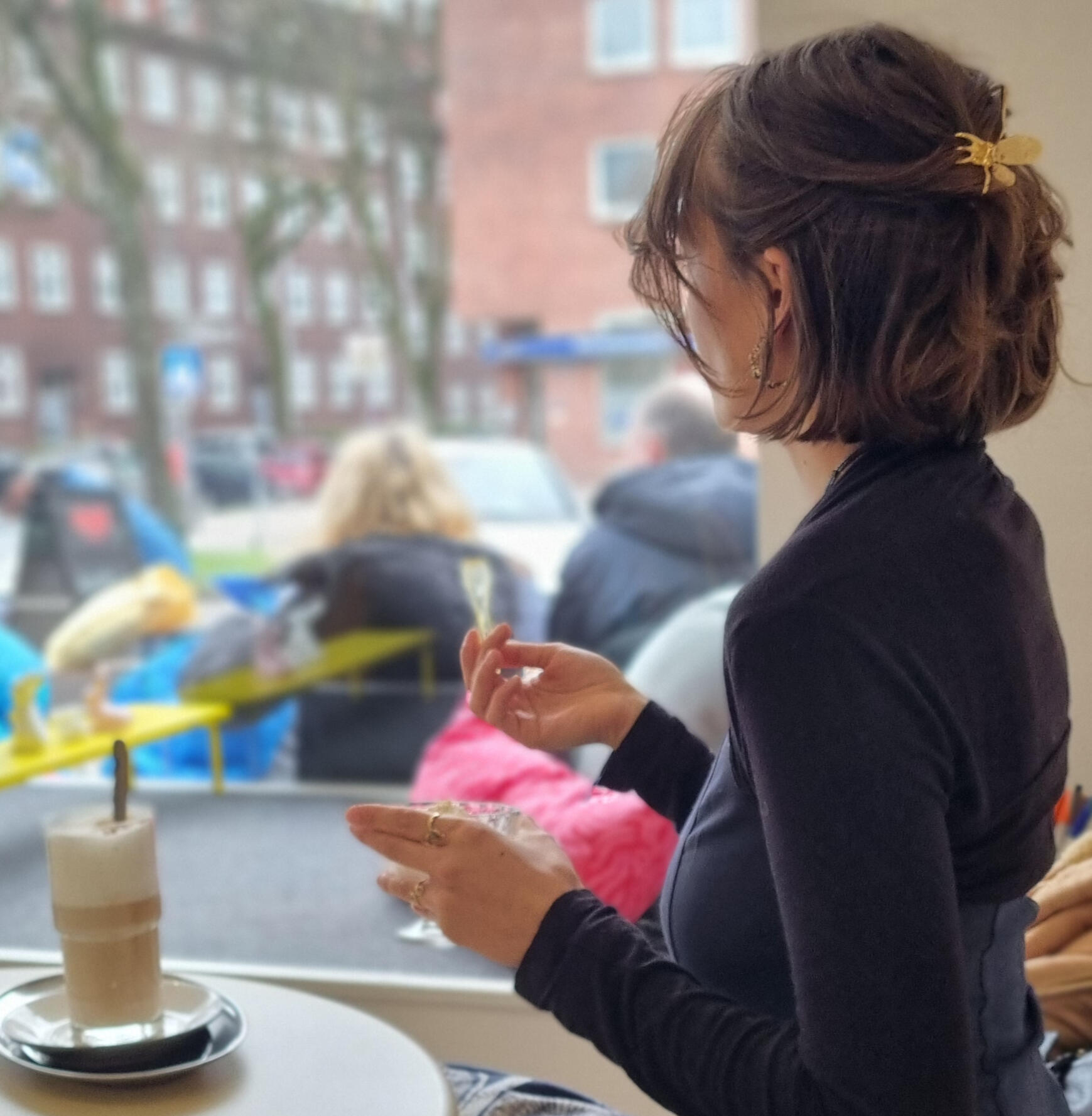 Ein ruhiger Moment im Eiscafé, Frau sitzt am Fenster und genießt einen Eiscafe Kaffee und ein ruhiger Moment am Fenster im Eiscafé.